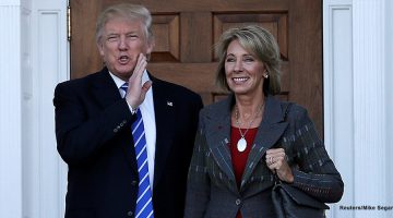 Donald Trump (L) stands with Betsy DeVos