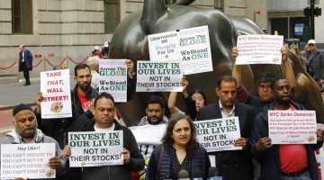 Uber drivers protesting next to the Charging Bull statue in New York's financial district.