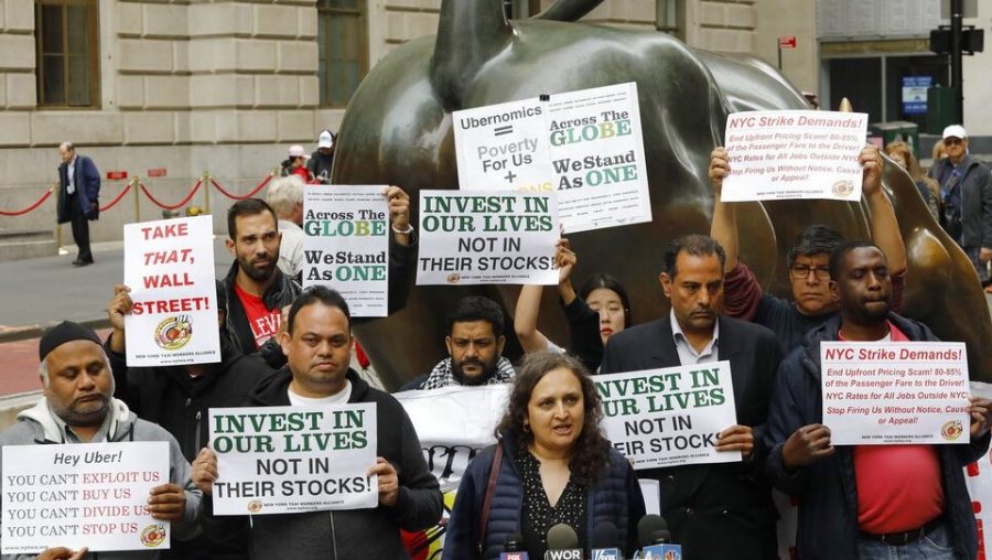 Uber drivers protesting next to the Charging Bull statue in New York's financial district.